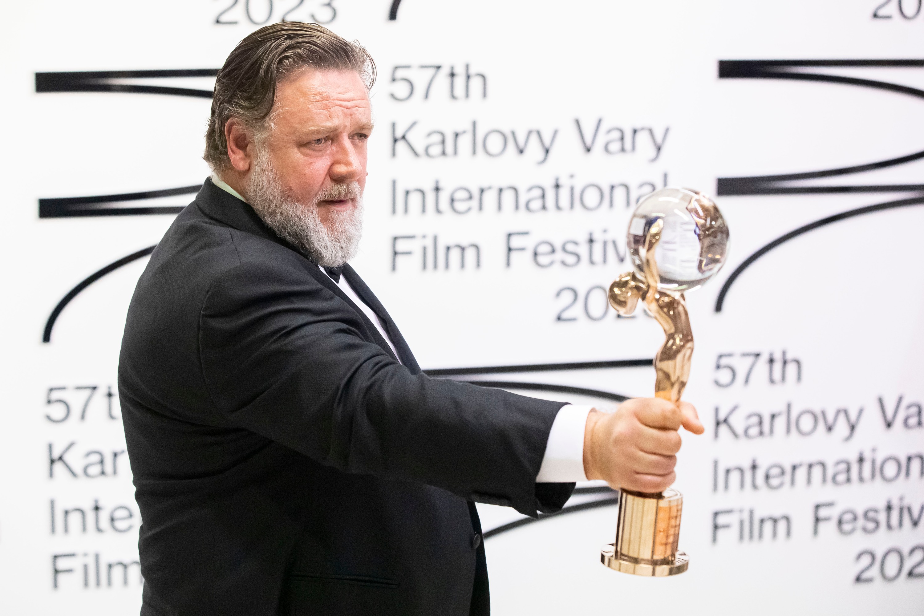 Actor Russell Crowe raises his Crystal Globe Award on a red carpet during the 57th Karlovy Vary International Film Festival in the Czech Republic.